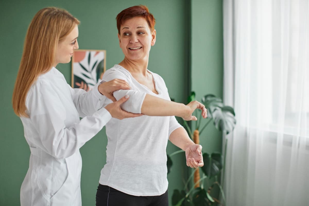 Physical therapist demonstrating tailored shoulder exercises to a patient as a first-choice treatment for recovery